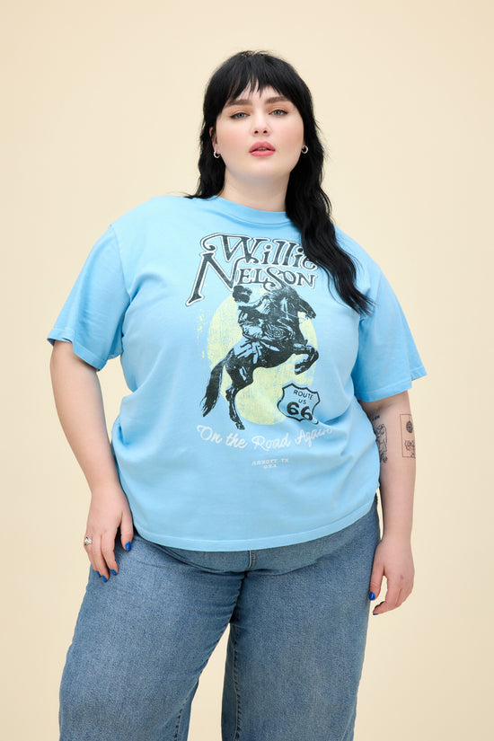 A model featuring a blue plus size weekend tee stamped with Willie Nelson and his route 66 album cover.