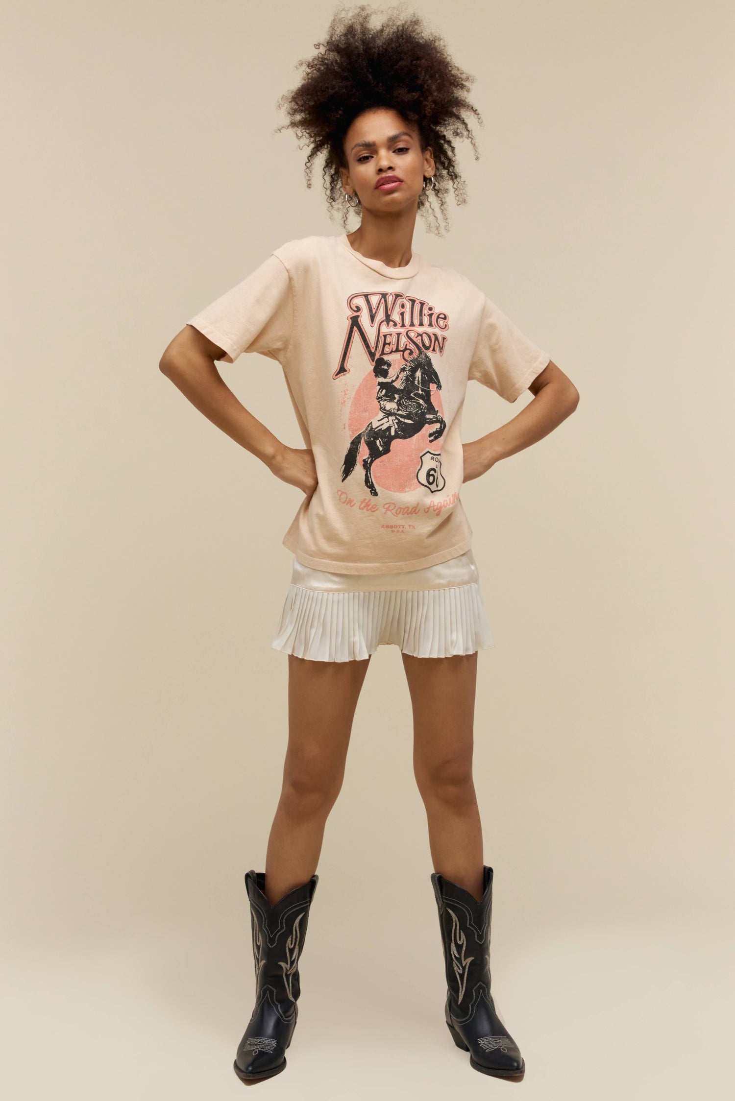 A model featuring a sand colored weekend tee stamped with Willie Nelson and his route 66 album cover.