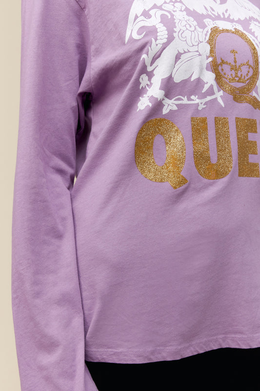 Model wearing a Queen long sleeve graphic tee with crest artwork and gold glitter accents
