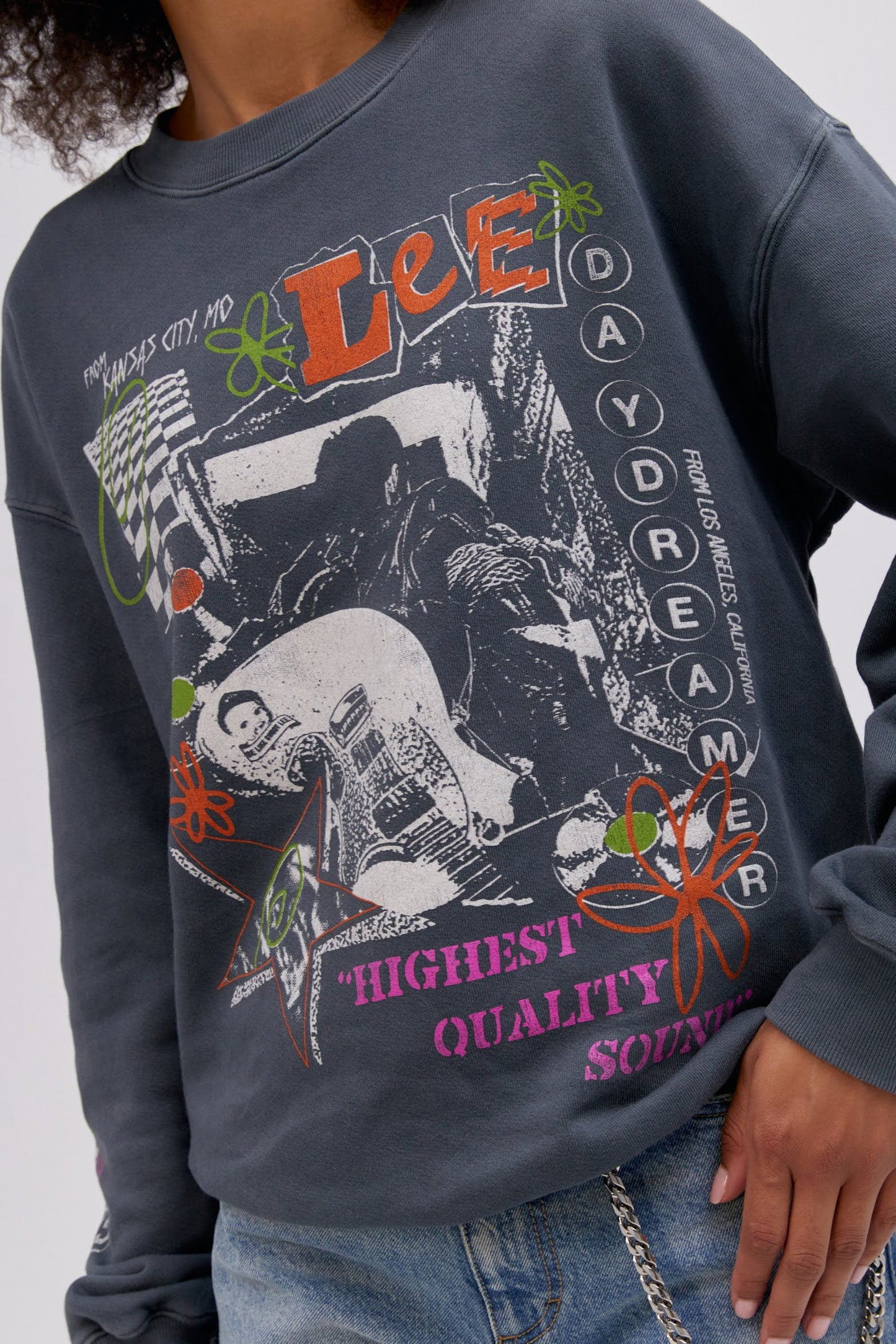 Close up detail photo of model wearing a Lee x Daydreamer collab graphic sweatshirt in washed black.