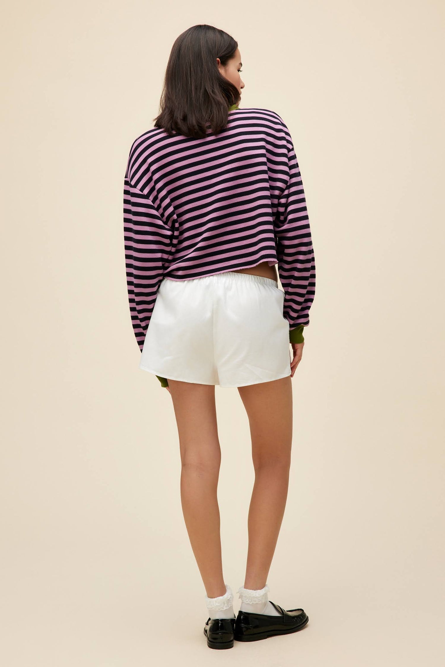 A model featuring a striped cut-off sweatshirt in lotus flower combo