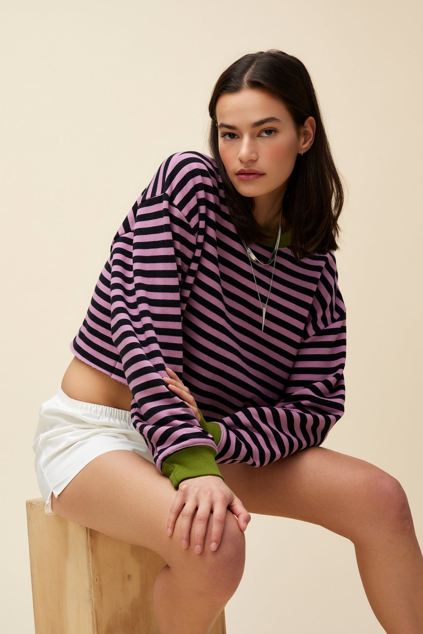 A model featuring a striped cut-off sweatshirt in lotus flower combo