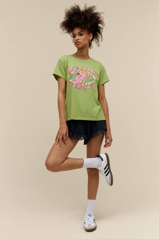 A model featuring a matcha colored tour tee stamped with Rolling Stones and their iconic logo.