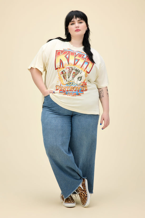 A model featuring a white plus size merch tee stamped with 'KISS' in large font.
