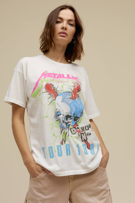 A model featuring vintage sunset colored merch tee stamped with Metallica and a graphic skull on the middle.