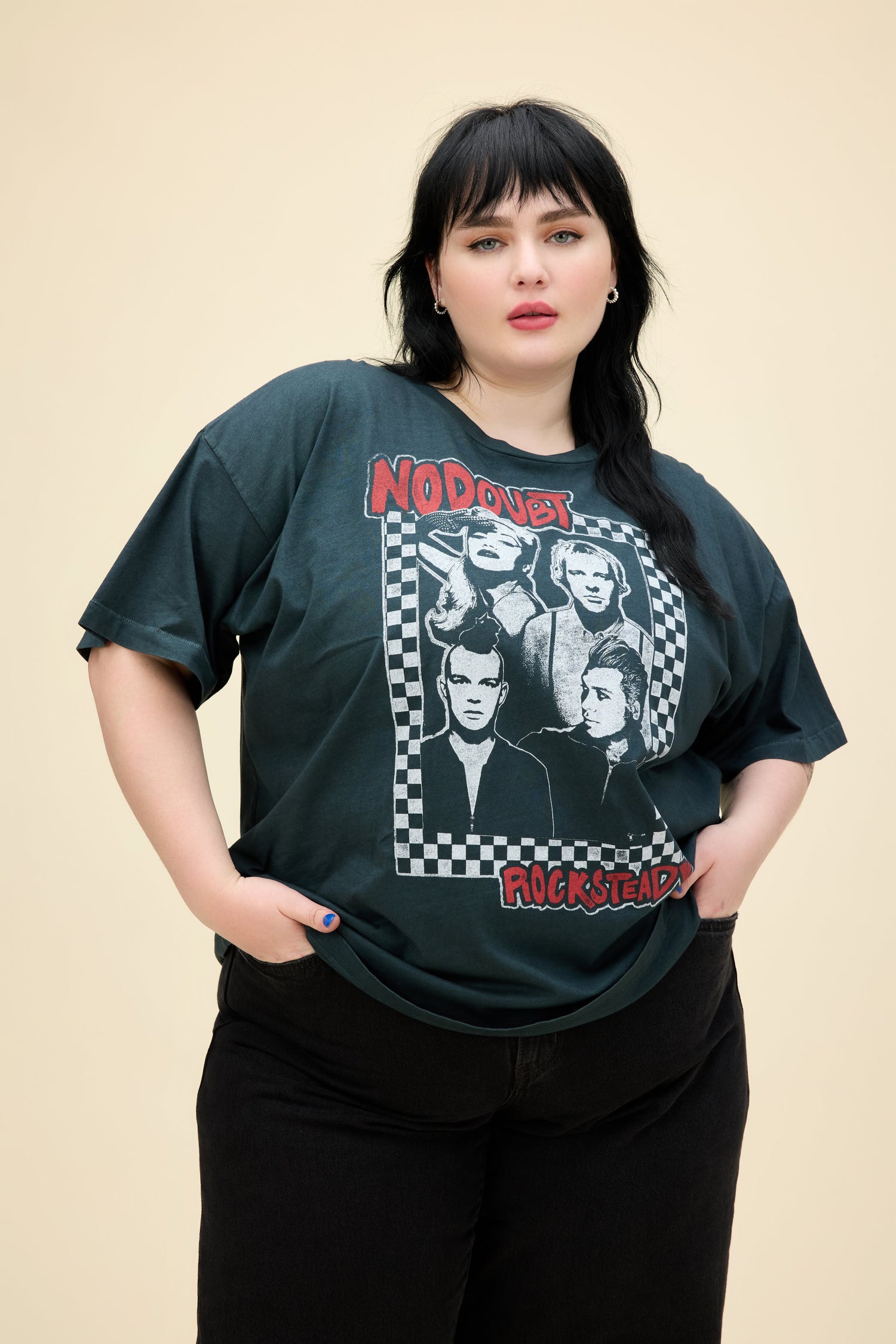A model featuring a black plus size merch tee design with a group photo of the No Doubt band.