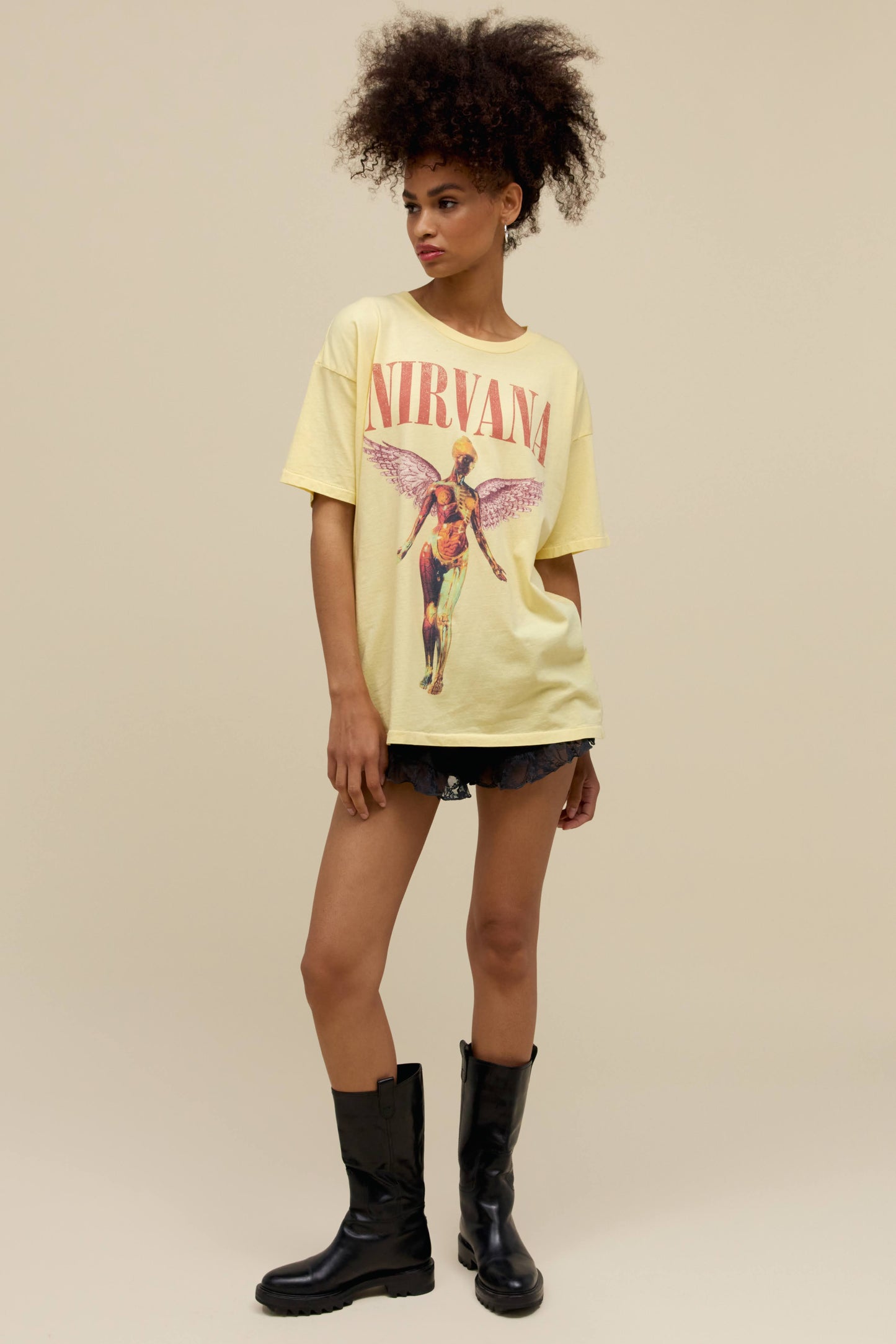 A model featuring a yellow mist colored merch tee stamped with Nirvana's Utero album cover.