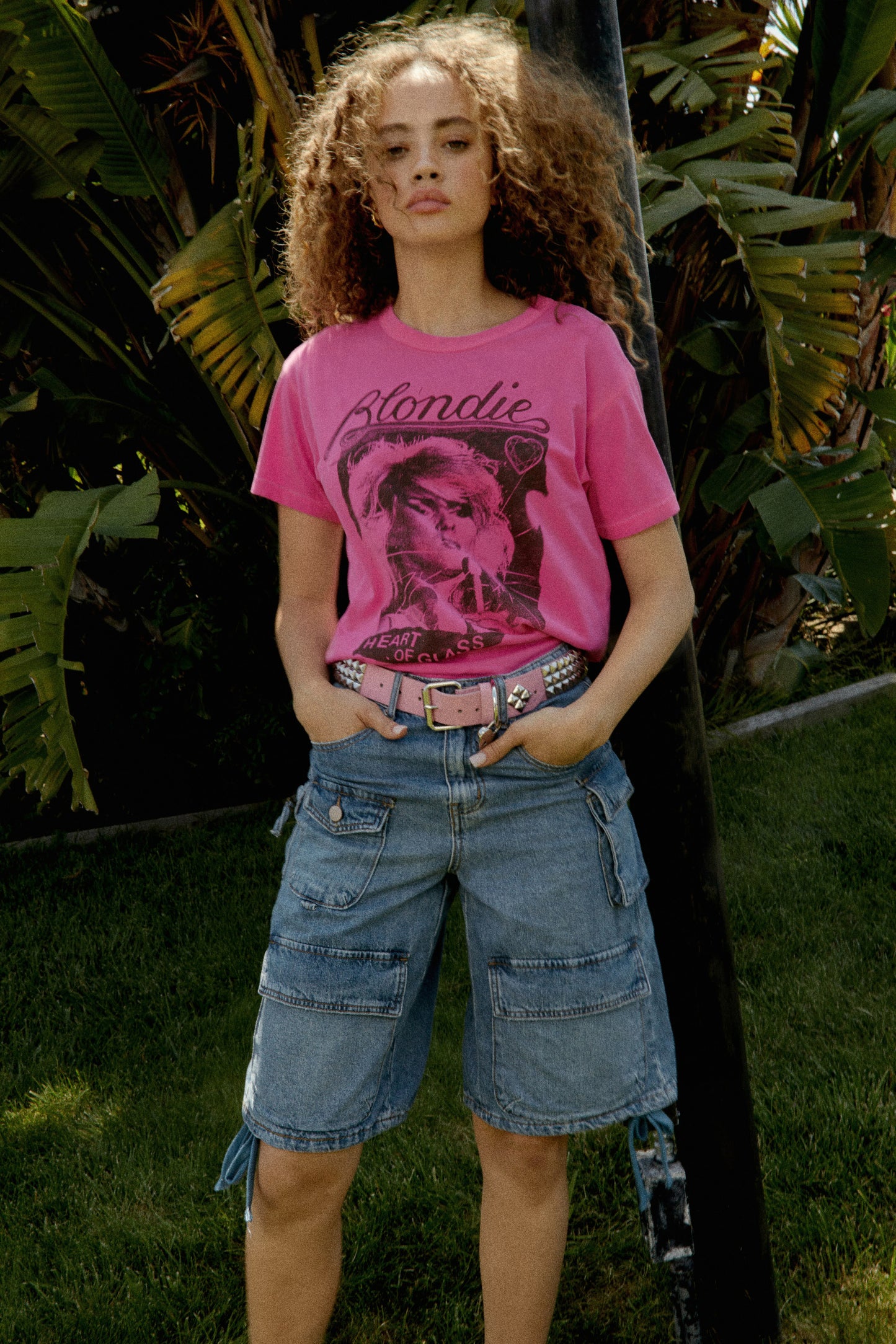 Model wearing Blondie graphic tee in pink with "Heart Of Glass" artwork on front.