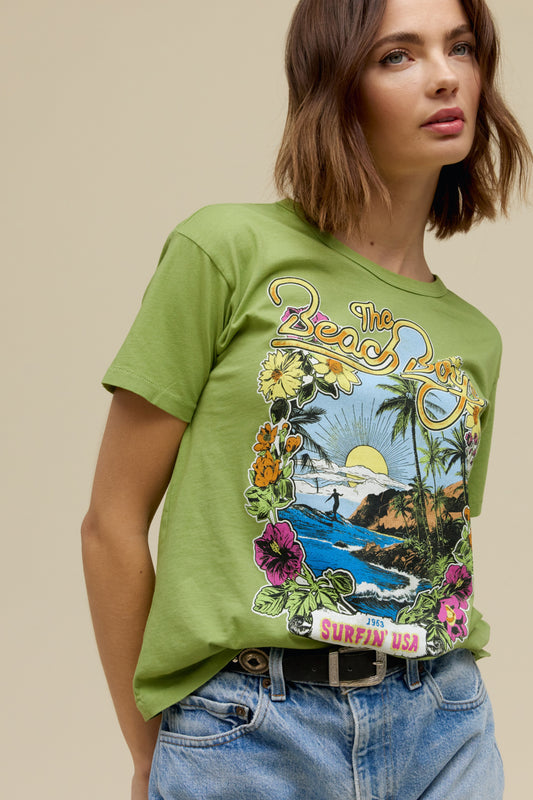 A model featuring a matcha ringer tee stamped with 'The Beach Boys', with their graphic beach logo.