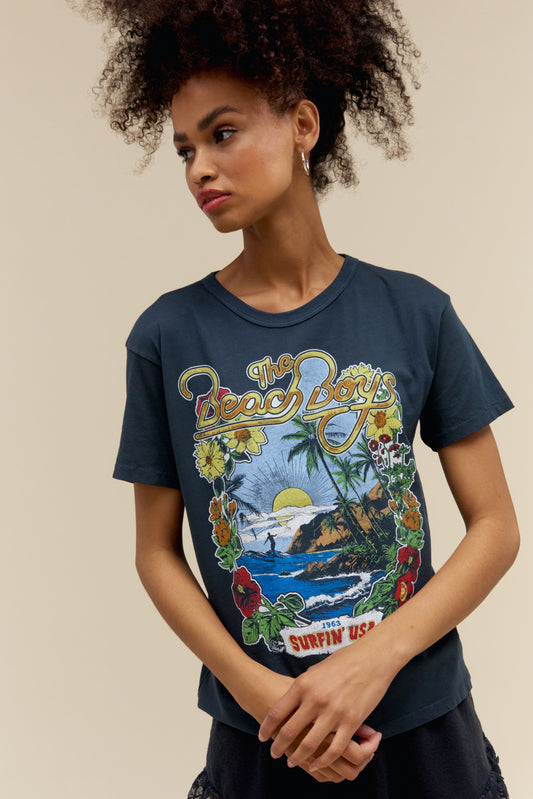 A model featuring a black ringer tee stamped with 'The Beach Boys', with their graphic beach logo.