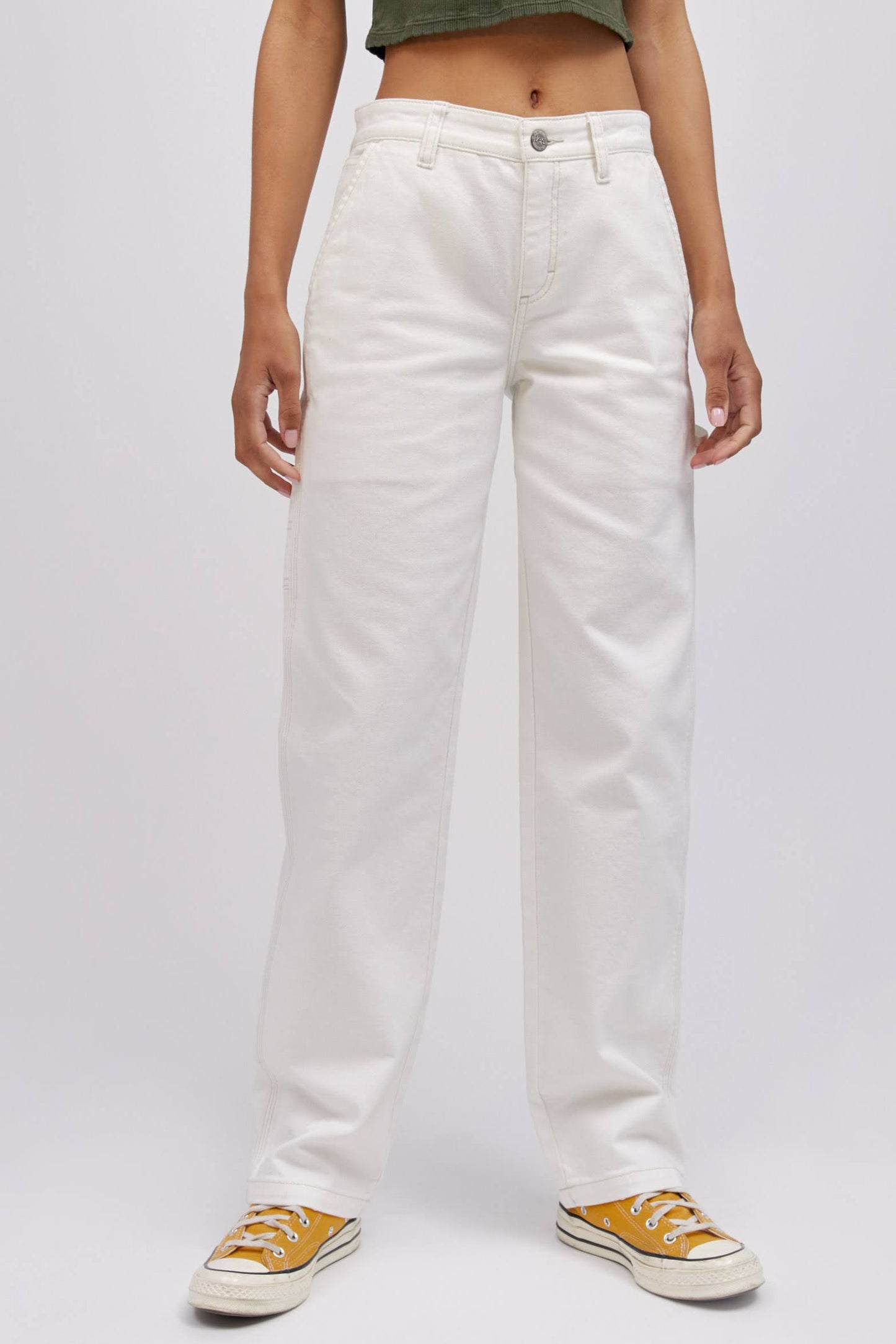 A  model featuring a white workwear pant made from heavy cotton, accented with key Lee detailing of triple-stitched seams, oversized pockets and a uniform like hammer loop.