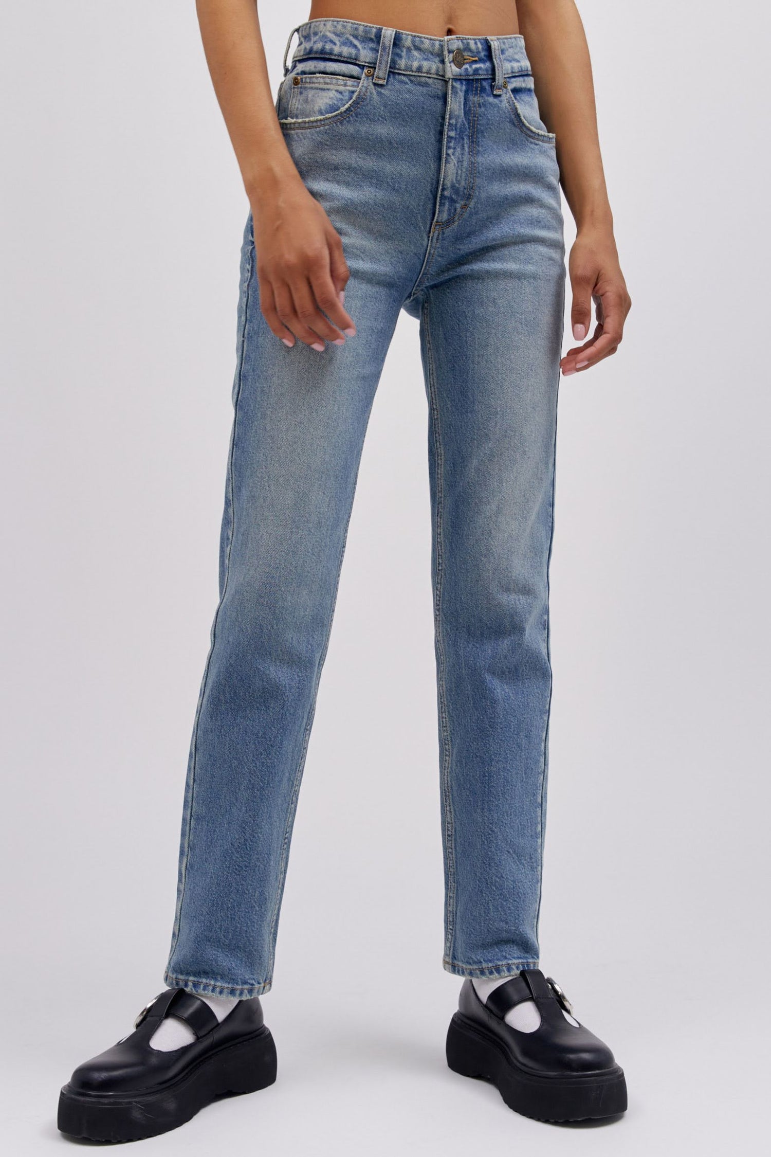 A model featuring a mid storm colored high rise and straight-legged jeans with a slim fit through the hips.