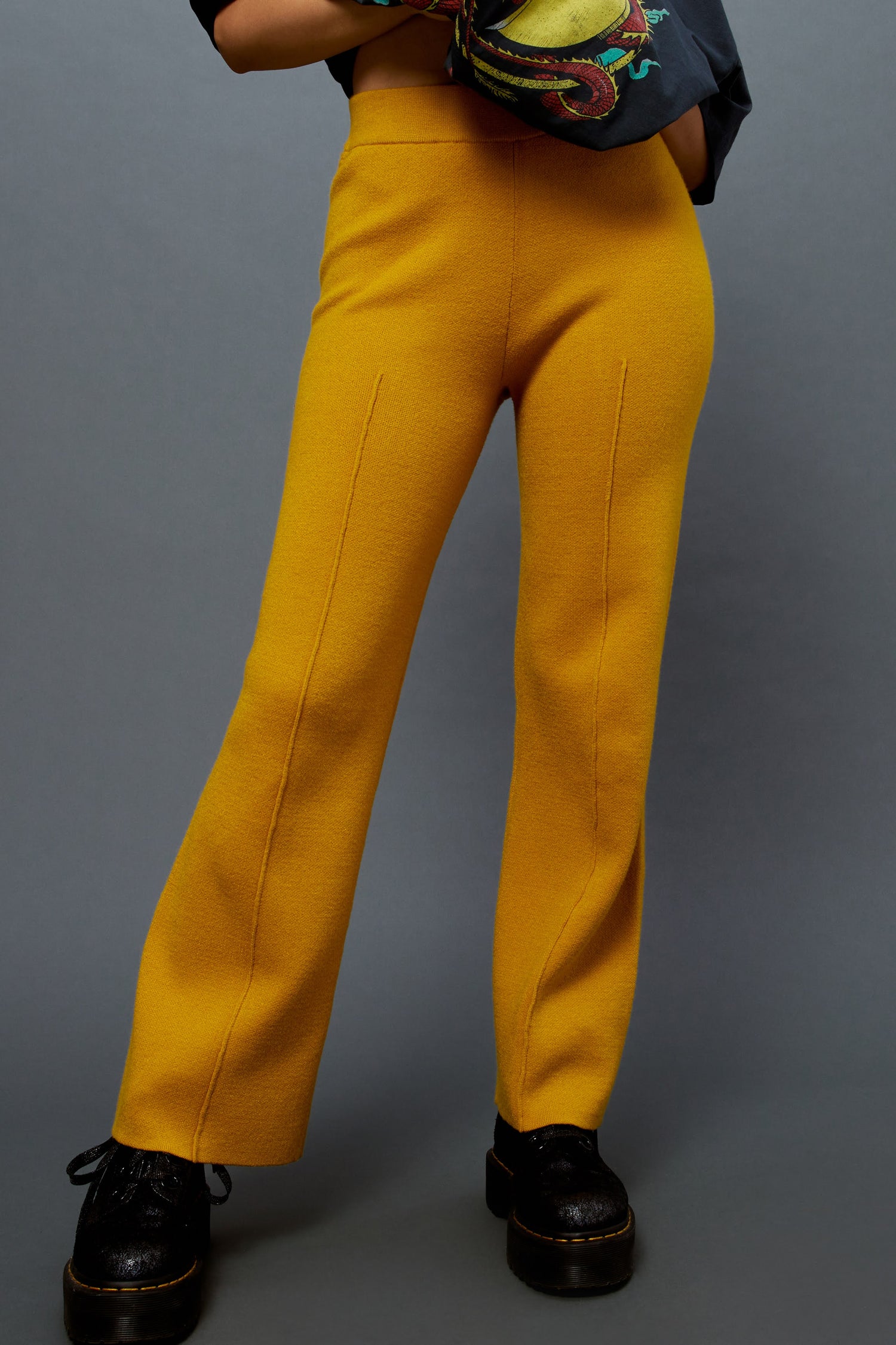 Model wearing knit pintuck pants in gold