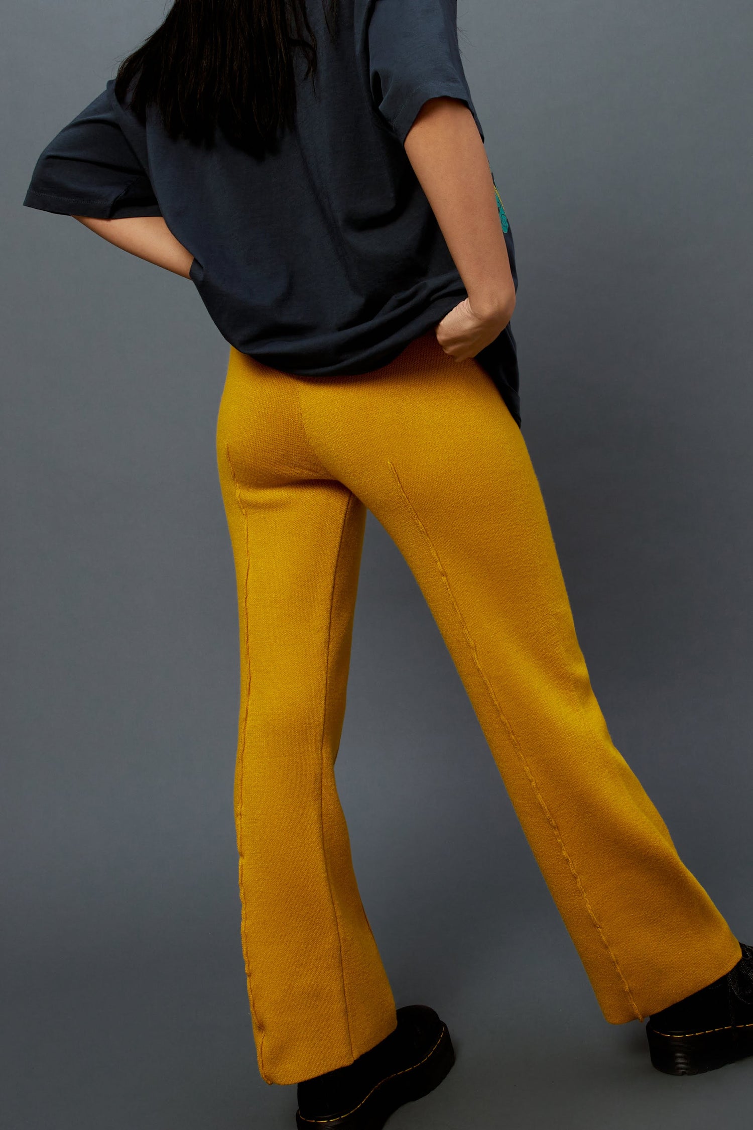Model wearing knit pintuck pants in gold