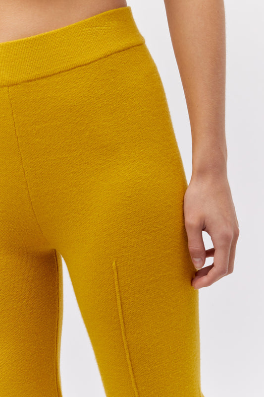 A model featuring a gold pintuck pant.