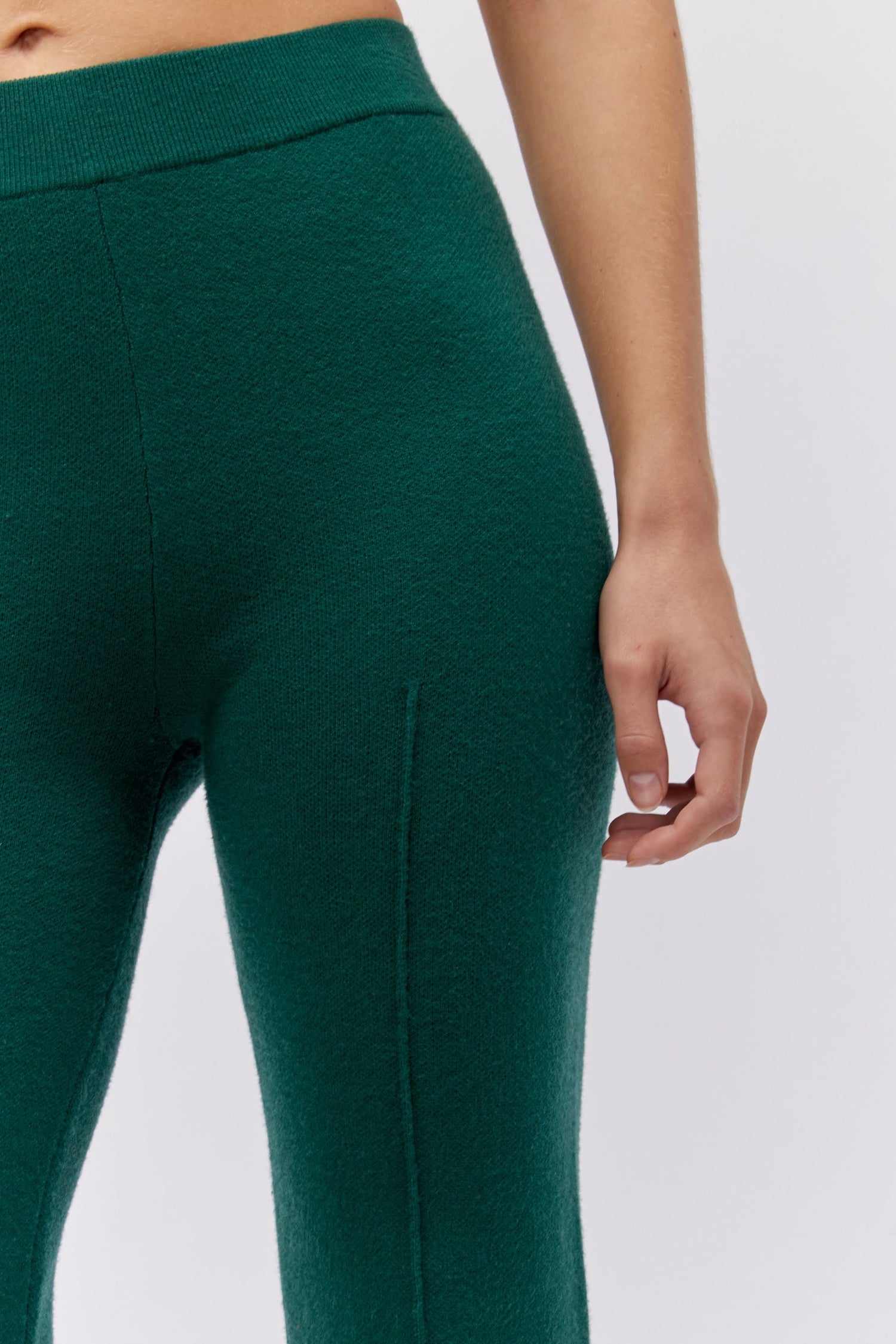 Model wearing a knit pintuck pant in hunter green.