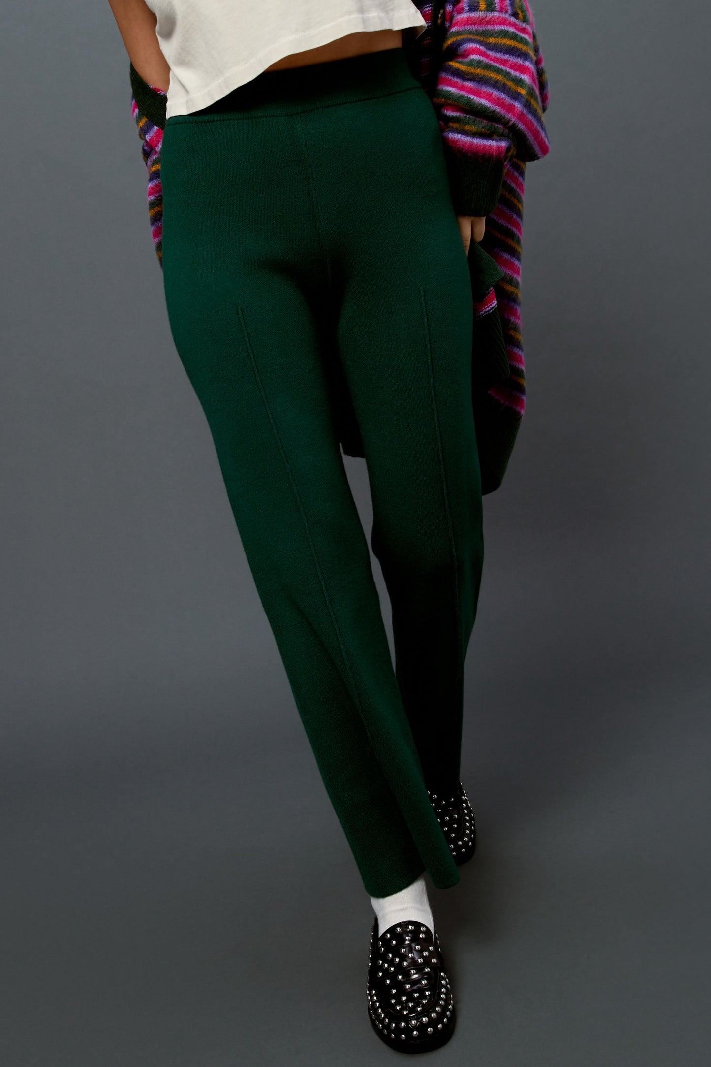 Model wearing a pair of knit pintuck pants in hunter green