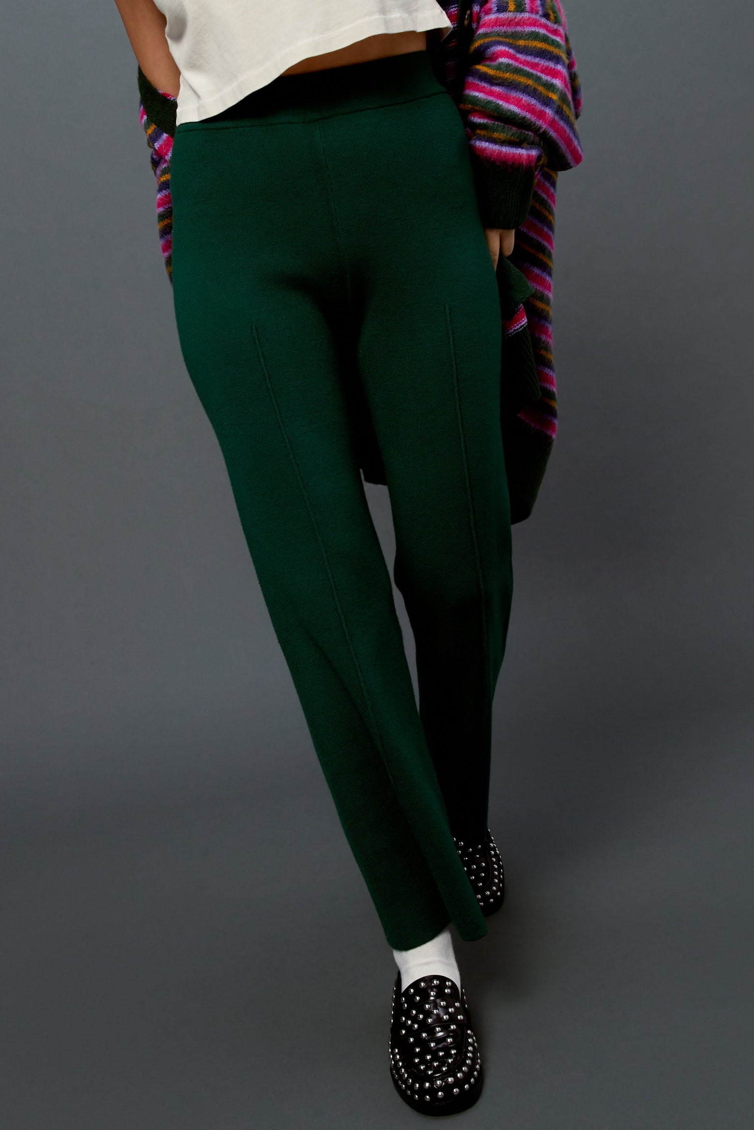 Model wearing a pair of knit pintuck pants in hunter green