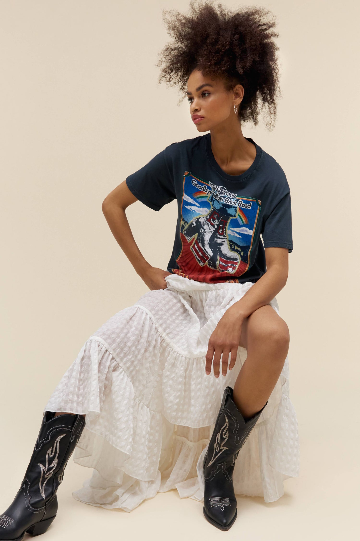 A model featuring a black boyfriend tee designed with a graphic boots in front and stamped with 'Elton John'.