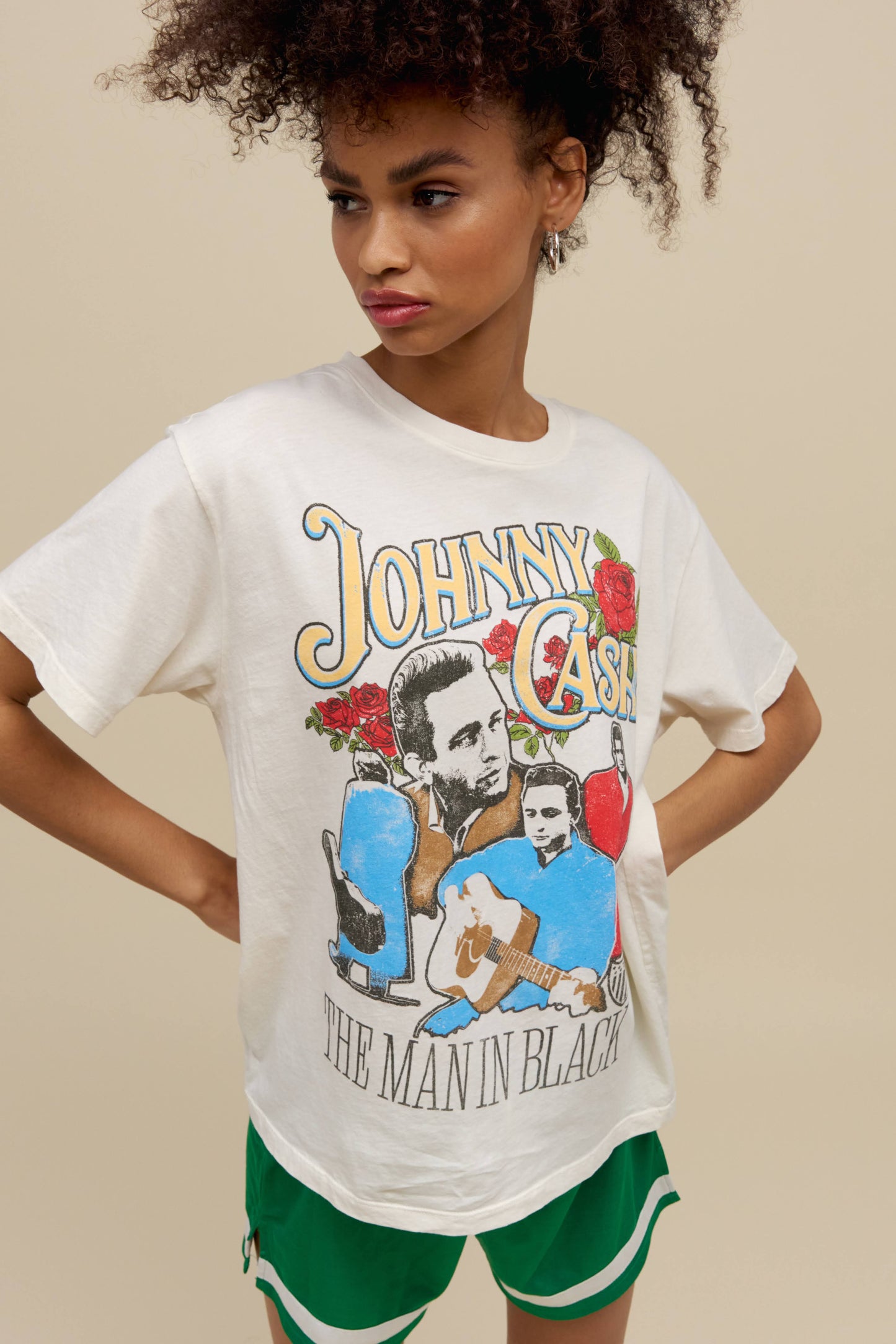 A model featuring a stone vintage tee designed with a portrait of the artist and stamped with 'Johnny Cash' on top.