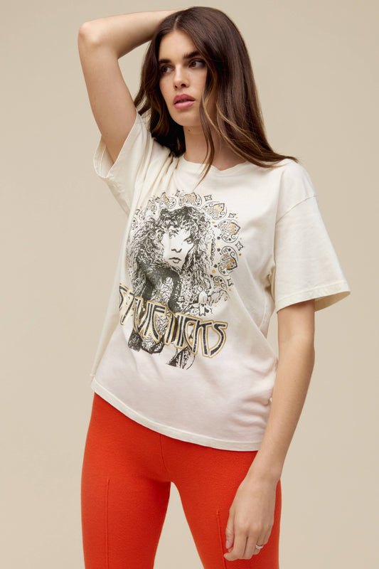A model featuring a white tee designed with a portrait fit to represent the icon’s free-spirited energy and 70s bohemian style lands center accented in metallic ink.