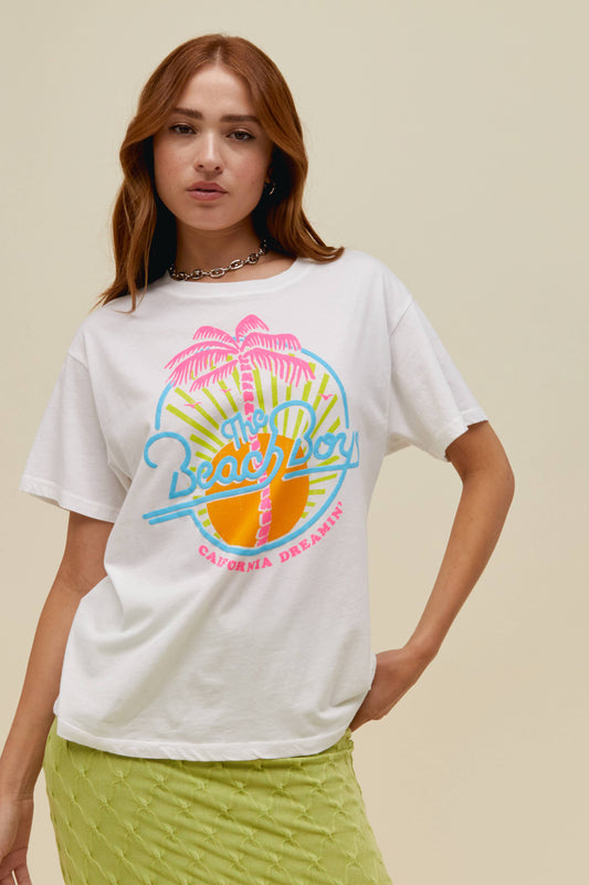 A model featuring a white tee stamped with "The Beach Boys" in front of a coconut and sun graphic 