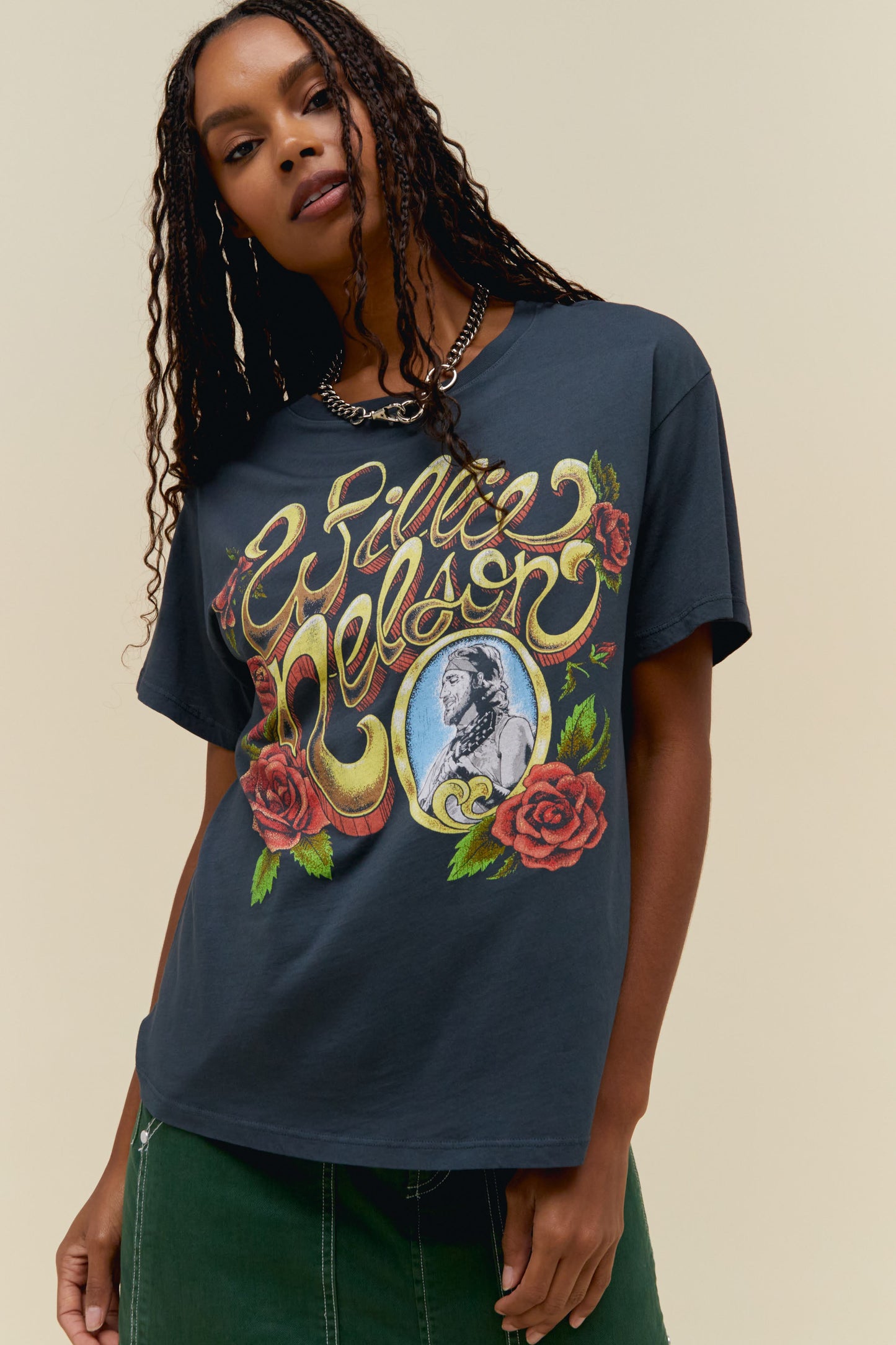 A model featuring a black tee stamped with "Willie Nelson" designed with roses around.