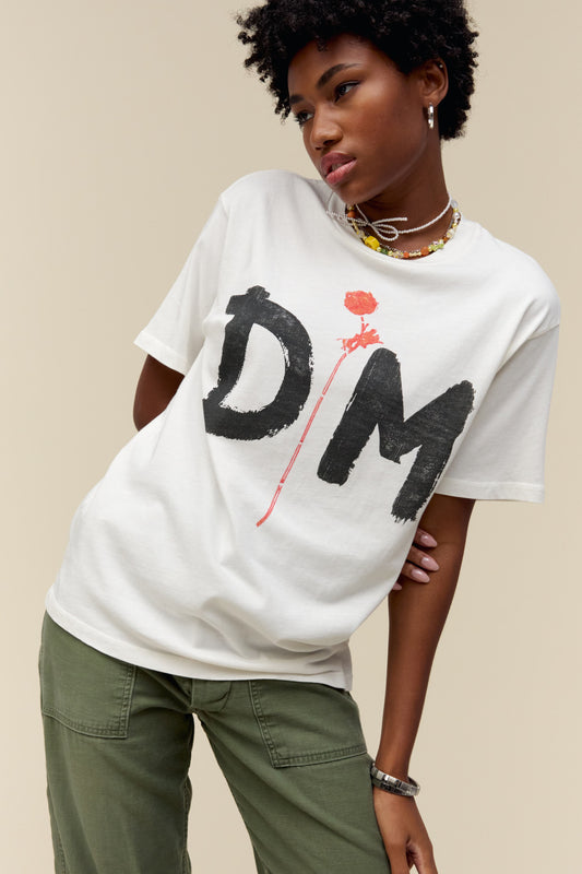 A model featuring a white tee stamped with 'DM' in black large font with a red rose in the middle.