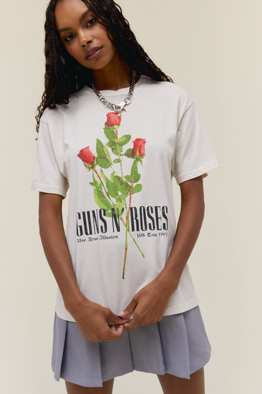 A model featuring a white weekend tee designed with flowers in the muddke and stamped with 'Guns N' Roses'