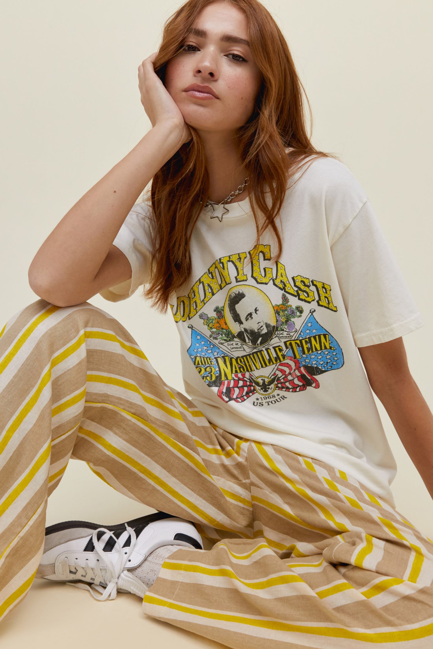 A model featuring a white tee stamped with "Johnny Cash" graphic in the center