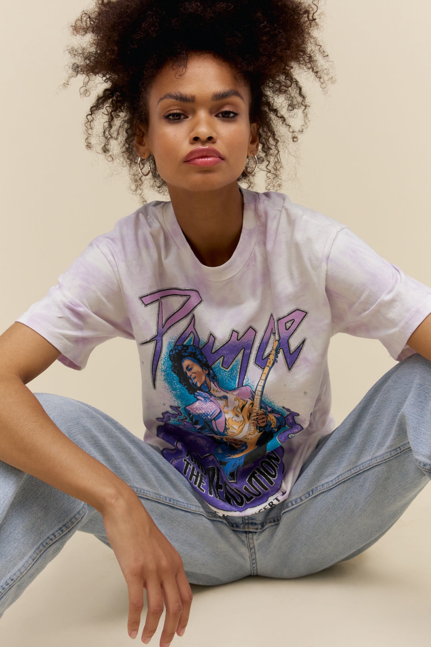 A model featuring a white tee designed with a photo of Prince performing at a concert.