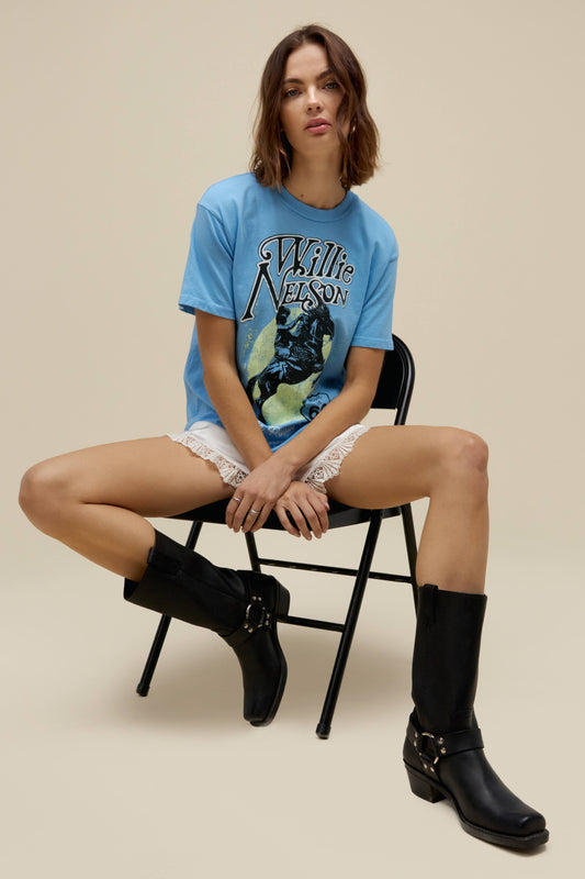 A model featuring a blue weekend tee stamped with Willie Nelson and his route 66 album cover.