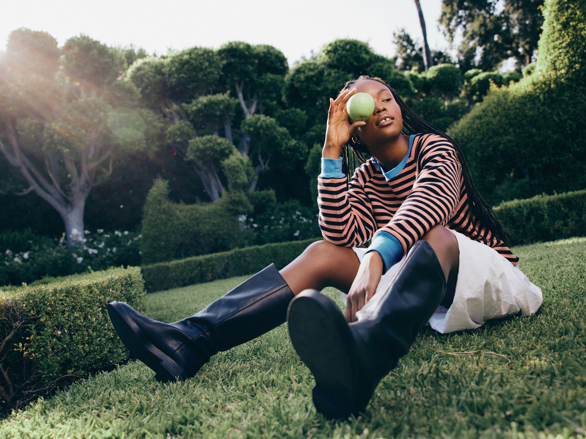 Model wearing a striped sweatshirt in grapefruit 