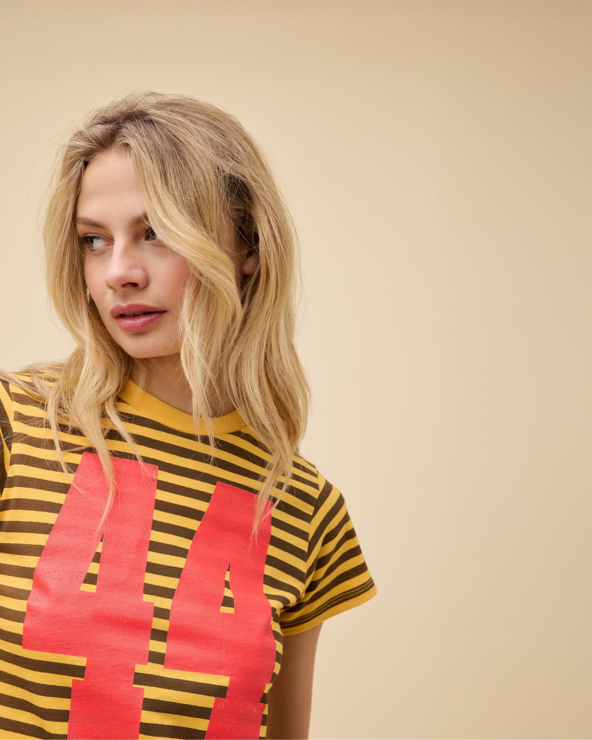 Model wearing a yellow striped shrunken tee with red '44' graphics