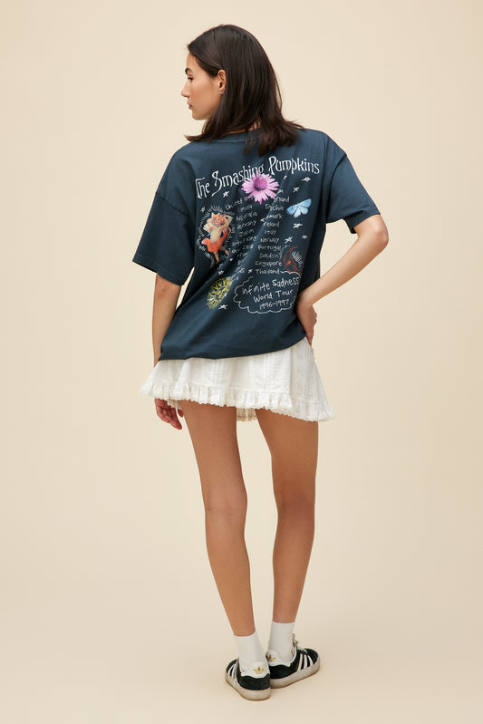 A model featuring a black tee designed with original artwork inspired by the album cover of "Mellon Collie and the Infinite Sadness". 