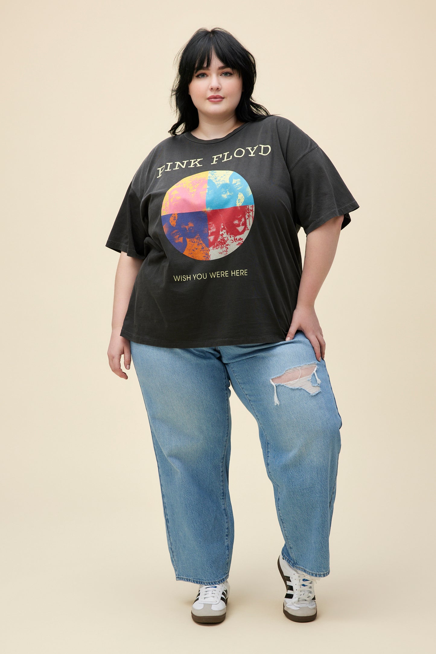 A model featuring a black tee ES designed with a distressed, multi-colored graphic image inspired by the main members of Pink Floyd stamped with "Wish you Were Here" below. 