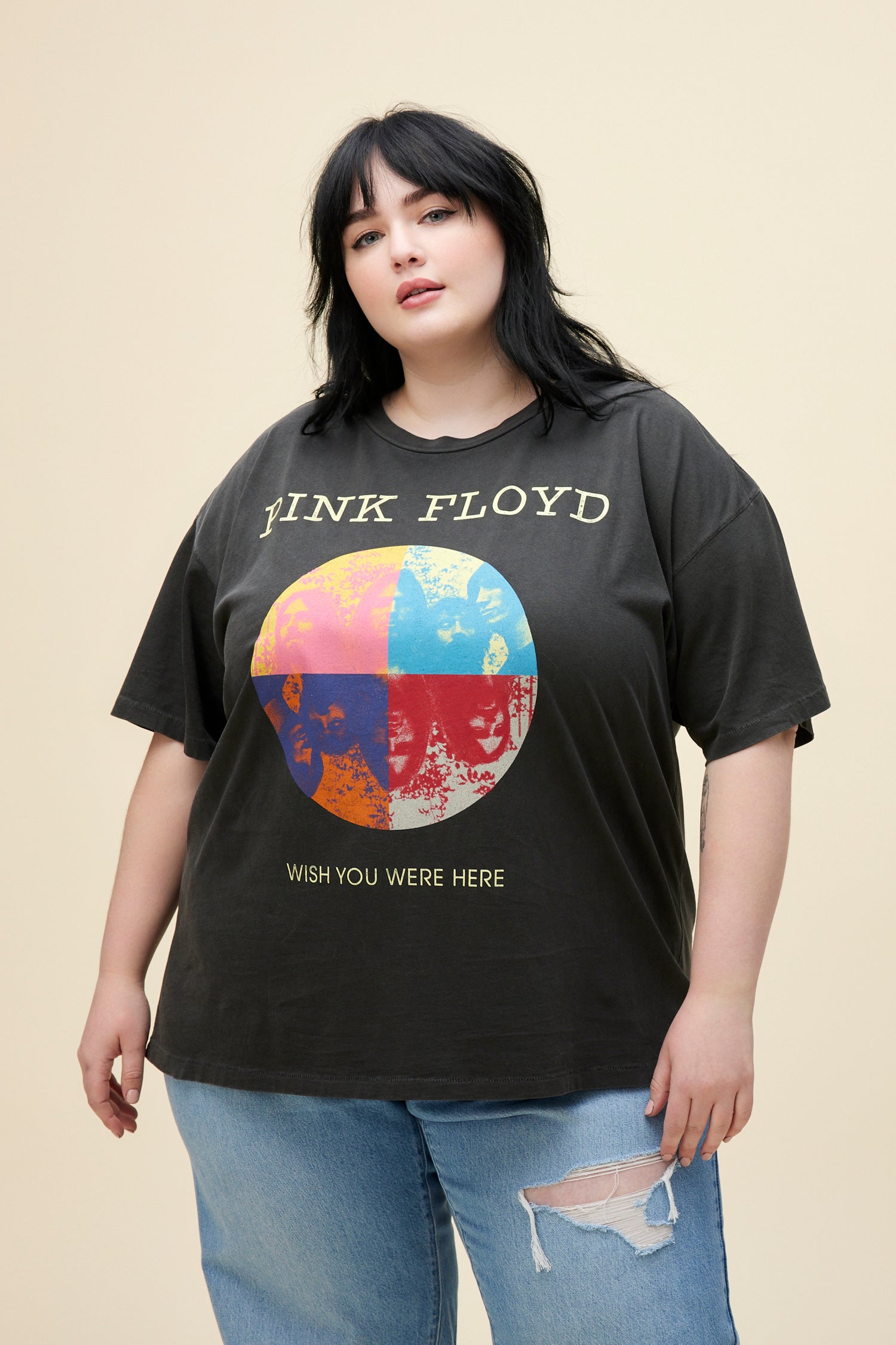 A model featuring a black tee ES designed with a distressed, multi-colored graphic image inspired by the main members of Pink Floyd stamped with "Wish you Were Here" below. 