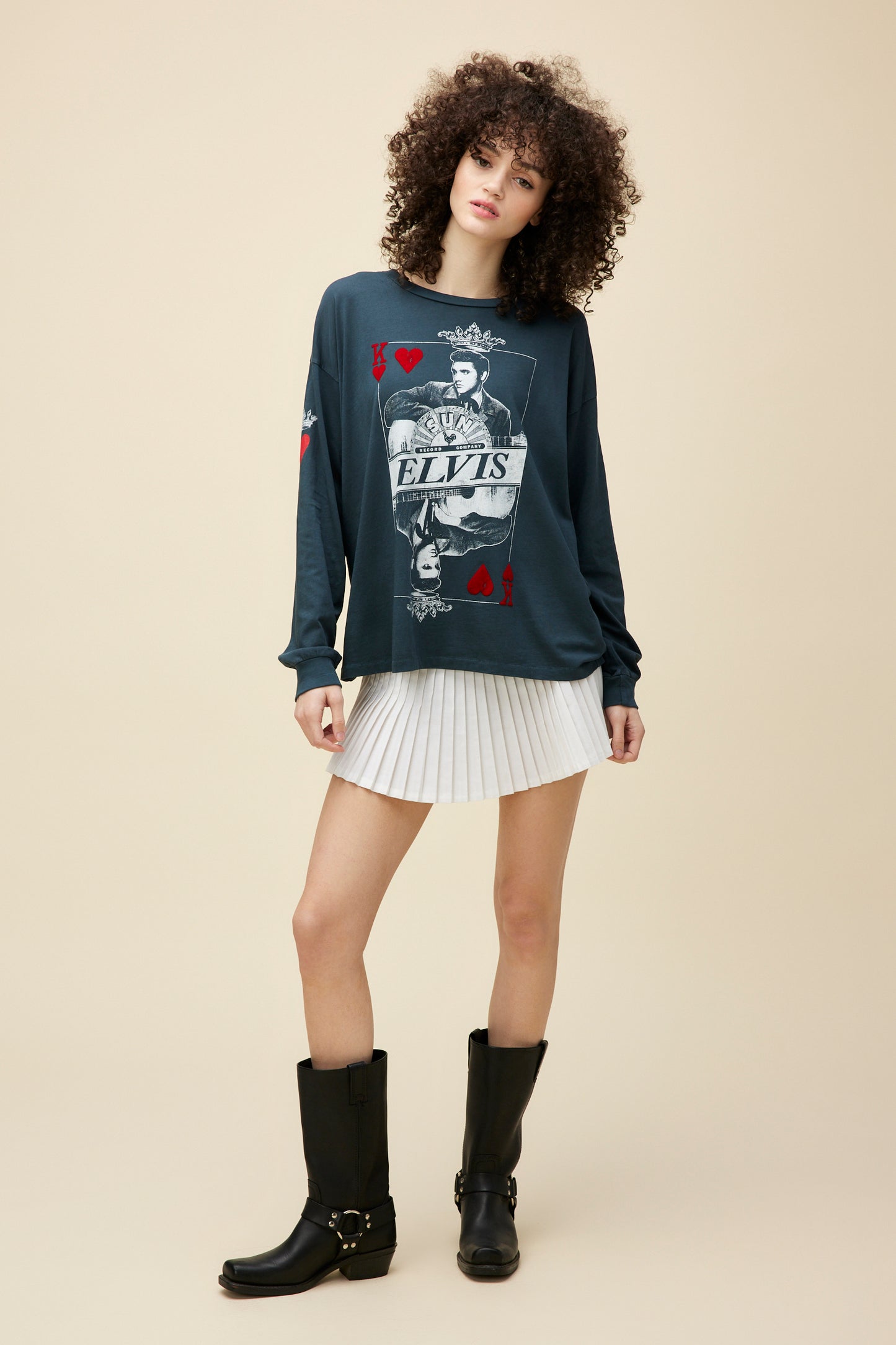 A model featuring a black, loose-fitting long sleeve, finished with red flocked accents on the front to accentuate the classic 'king of hearts' playing card design