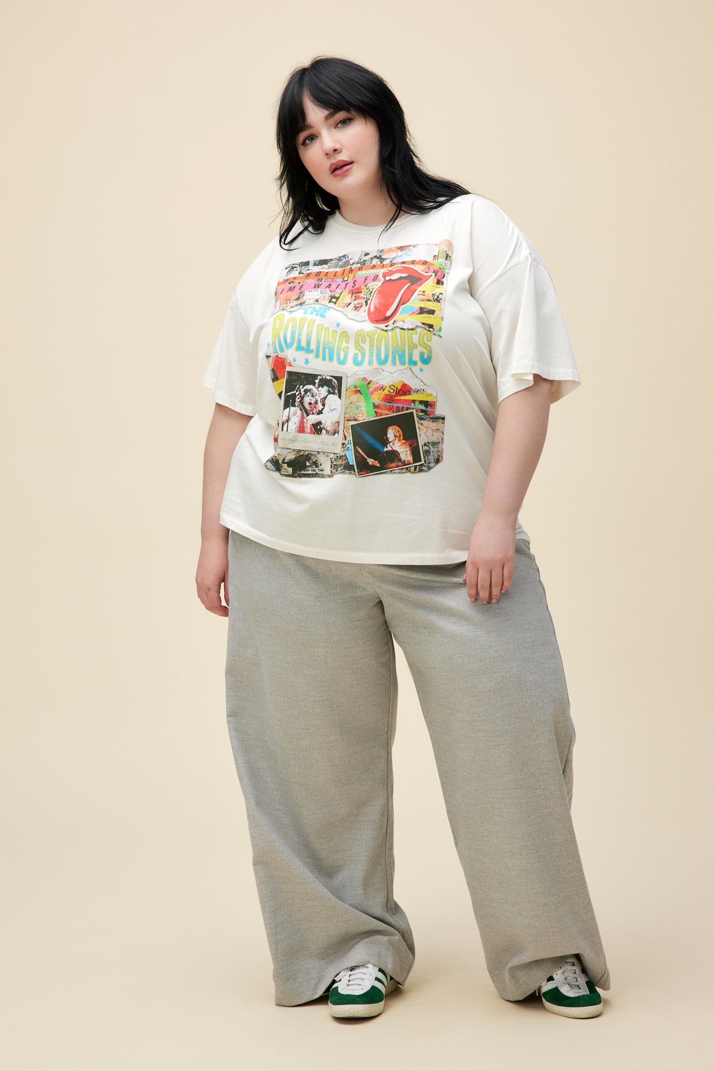 A model featuring a white tee ES stamped with 'The Rolling Stones' with collage pictures of the band performing at concerts.