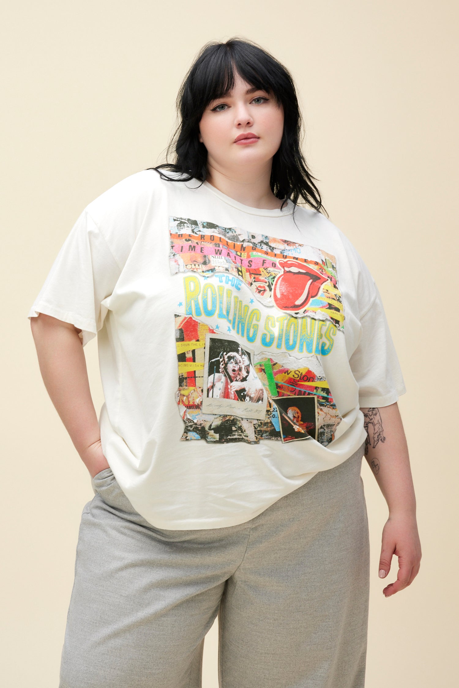 A model featuring a white tee ES stamped with 'The Rolling Stones' with collage pictures of the band performing at concerts.