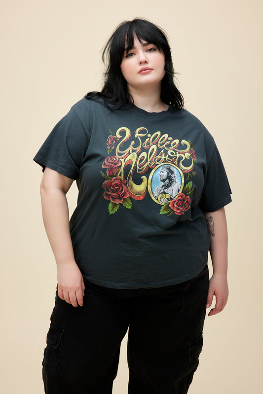 A model featuring a black tee ES stamped with "Willie Nelson" designed with roses around.