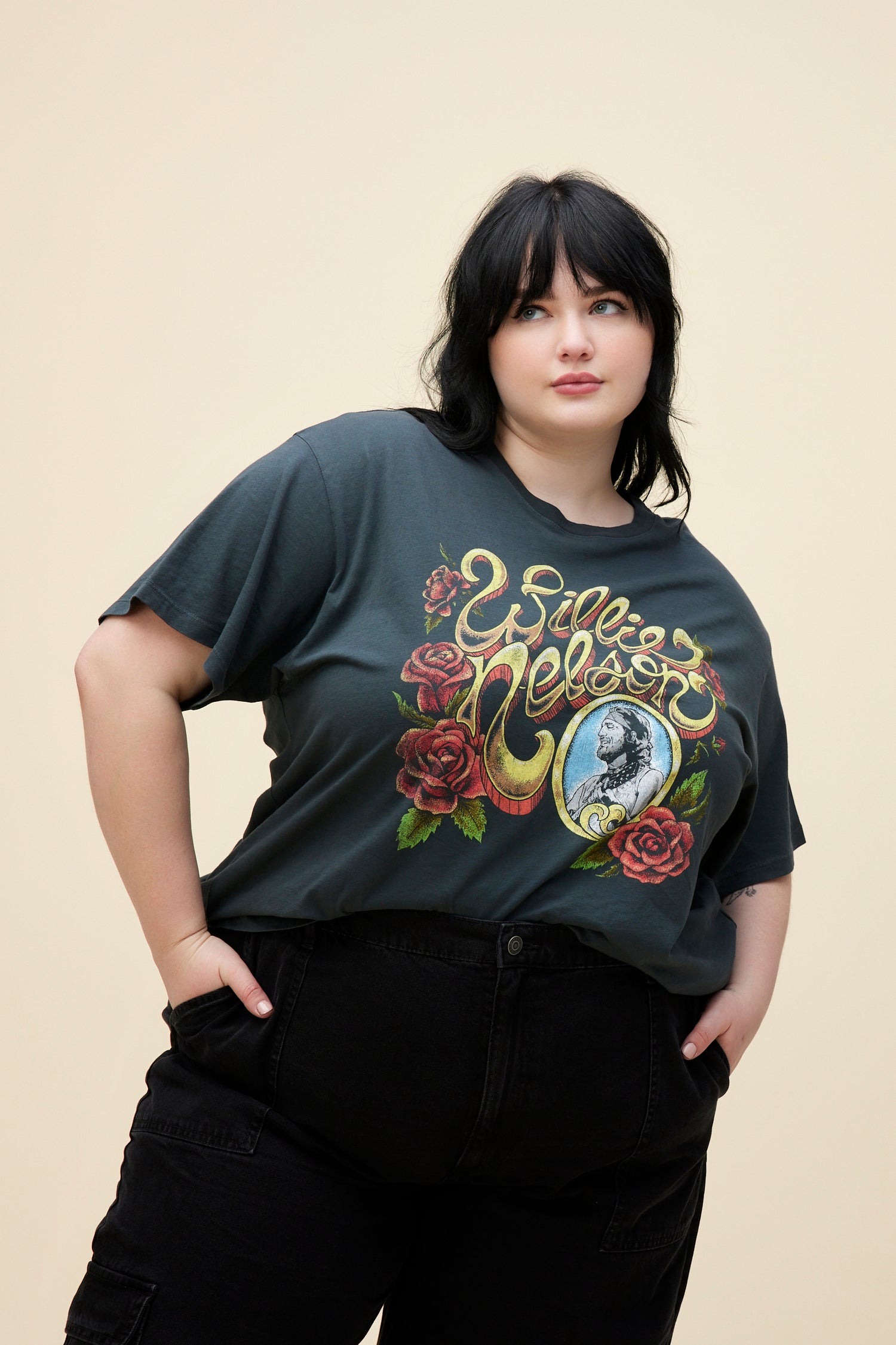 A model featuring a black tee ES stamped with "Willie Nelson" designed with roses around.