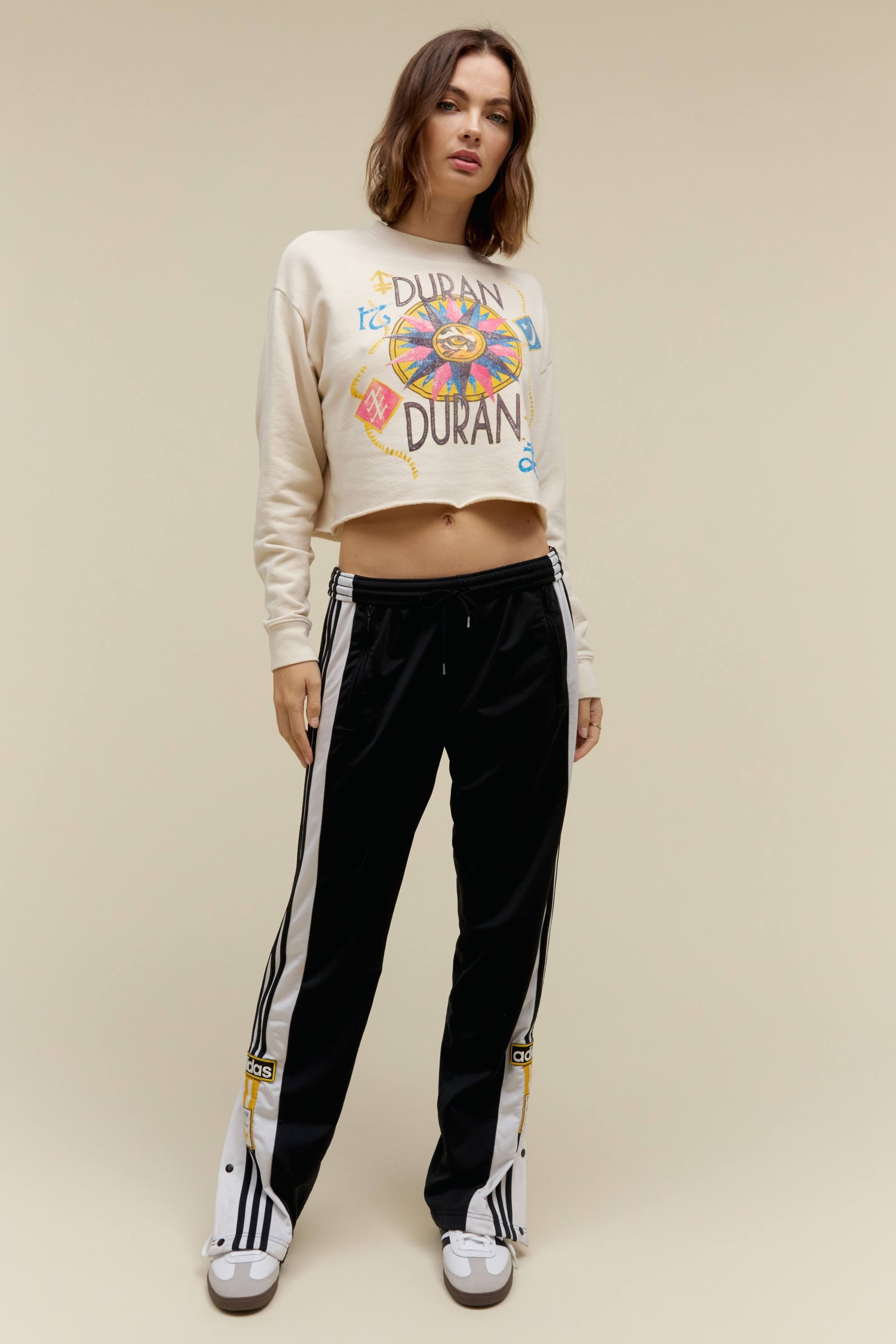 A model featuring a white cropped sweatshirt stamped  with 'Duran Duran'.