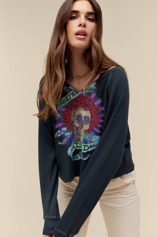 A model featuring a black vcut long sleeve designed with a graphic of a skull and stamped with grateful dead in green font.