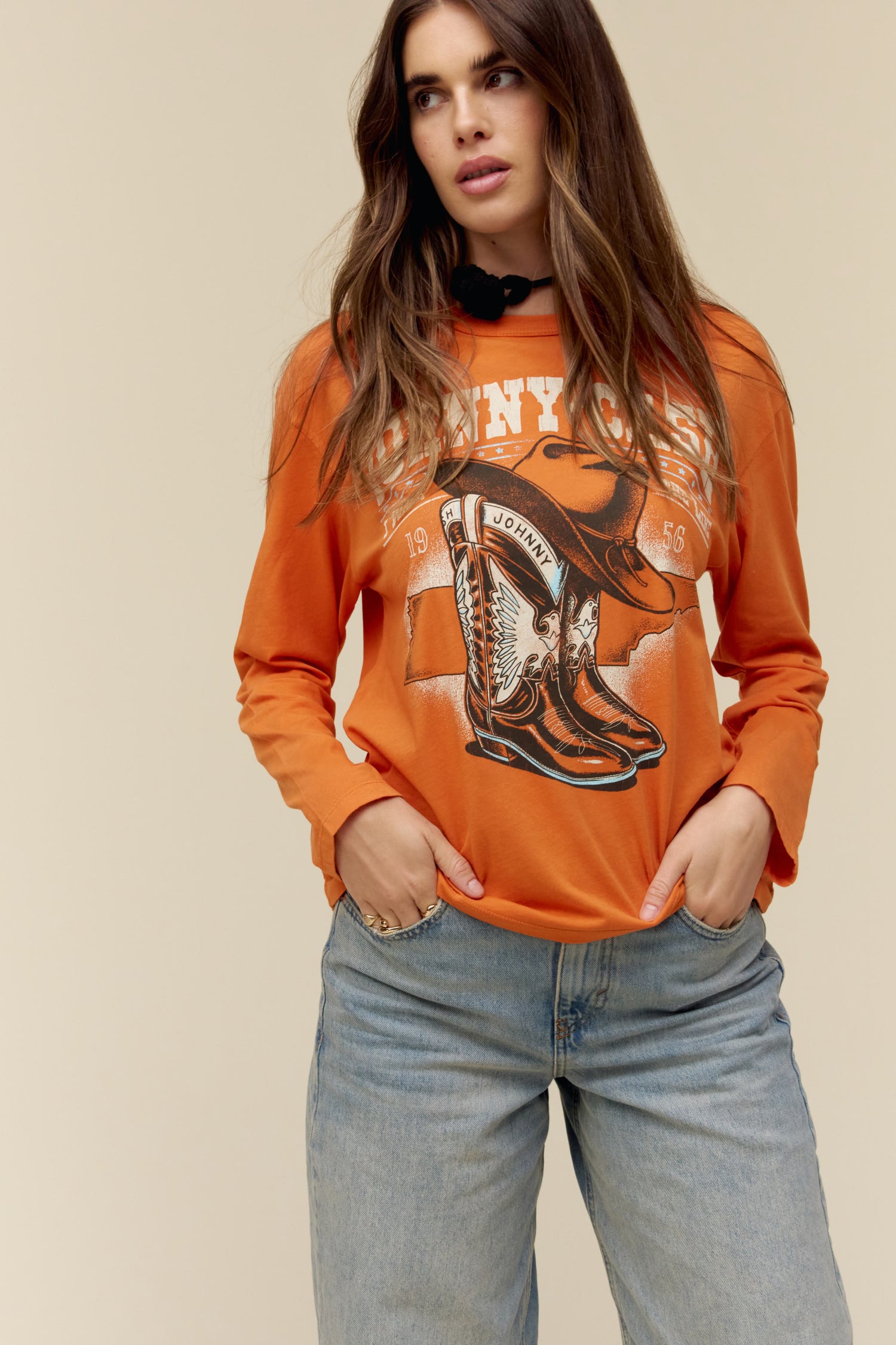 A model featuring an orange ls crew stamped with Johnny Cash and a graphic boot in the center.