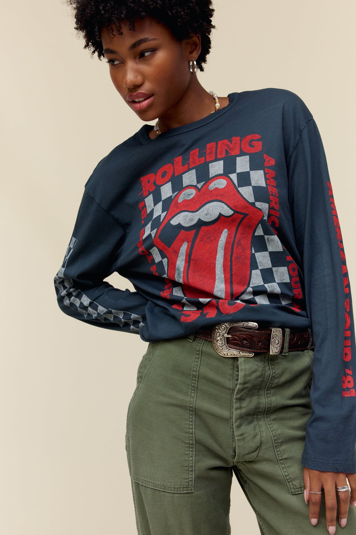 Model wearing a long sleeve Rolling Stones graphic tee with checkered accents and classic tongue logo