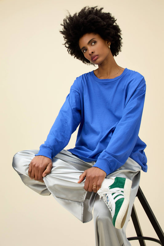 A model featuring a long sleeve merch in ultra marine.