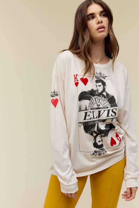 A model featuring a dirty white long sleeve designed with a king card and a portrait of Elvis stamped with his name.