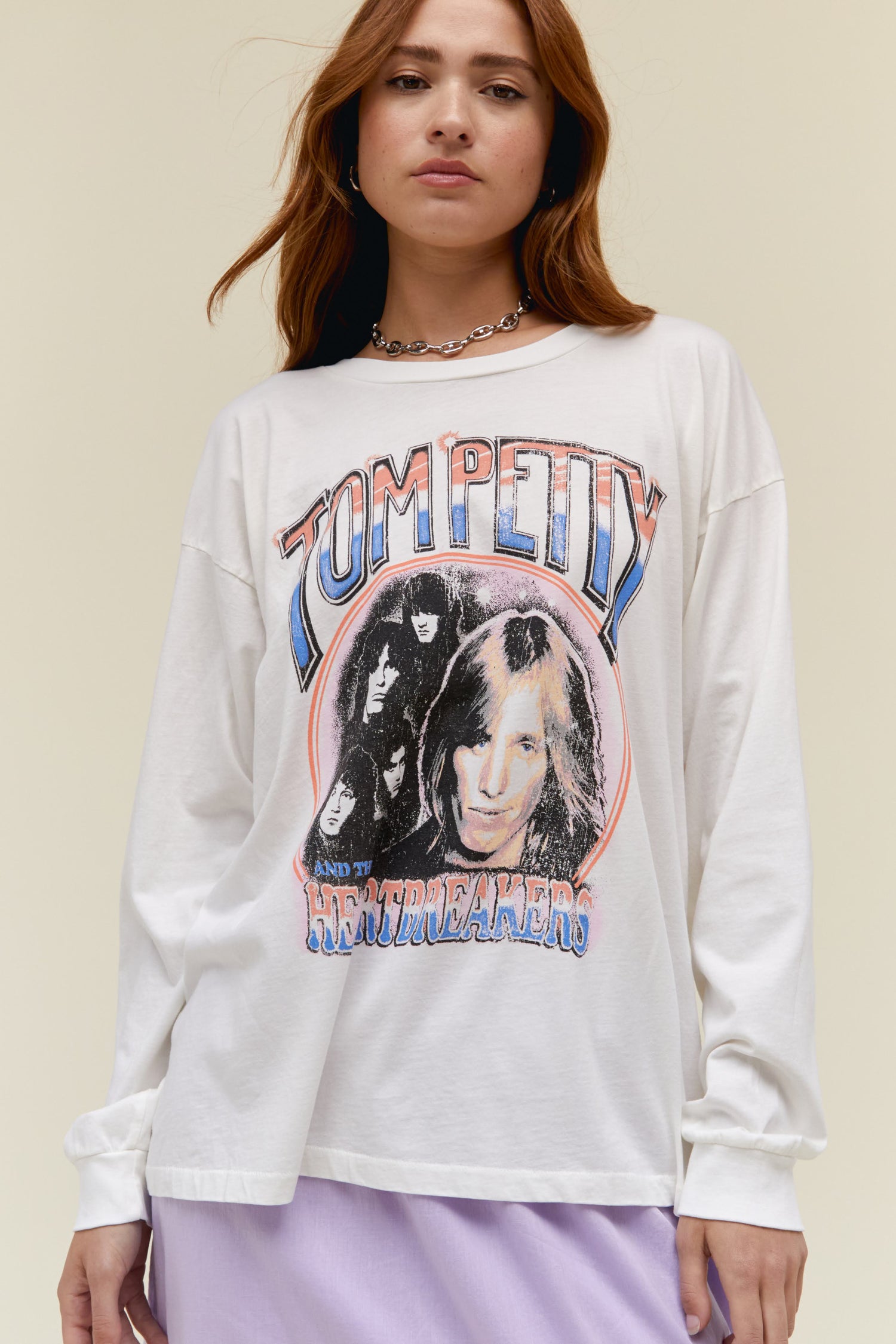 A model featuring a white long sleeve merch stamped with Tom Petty with a portrait of the  artist itself.