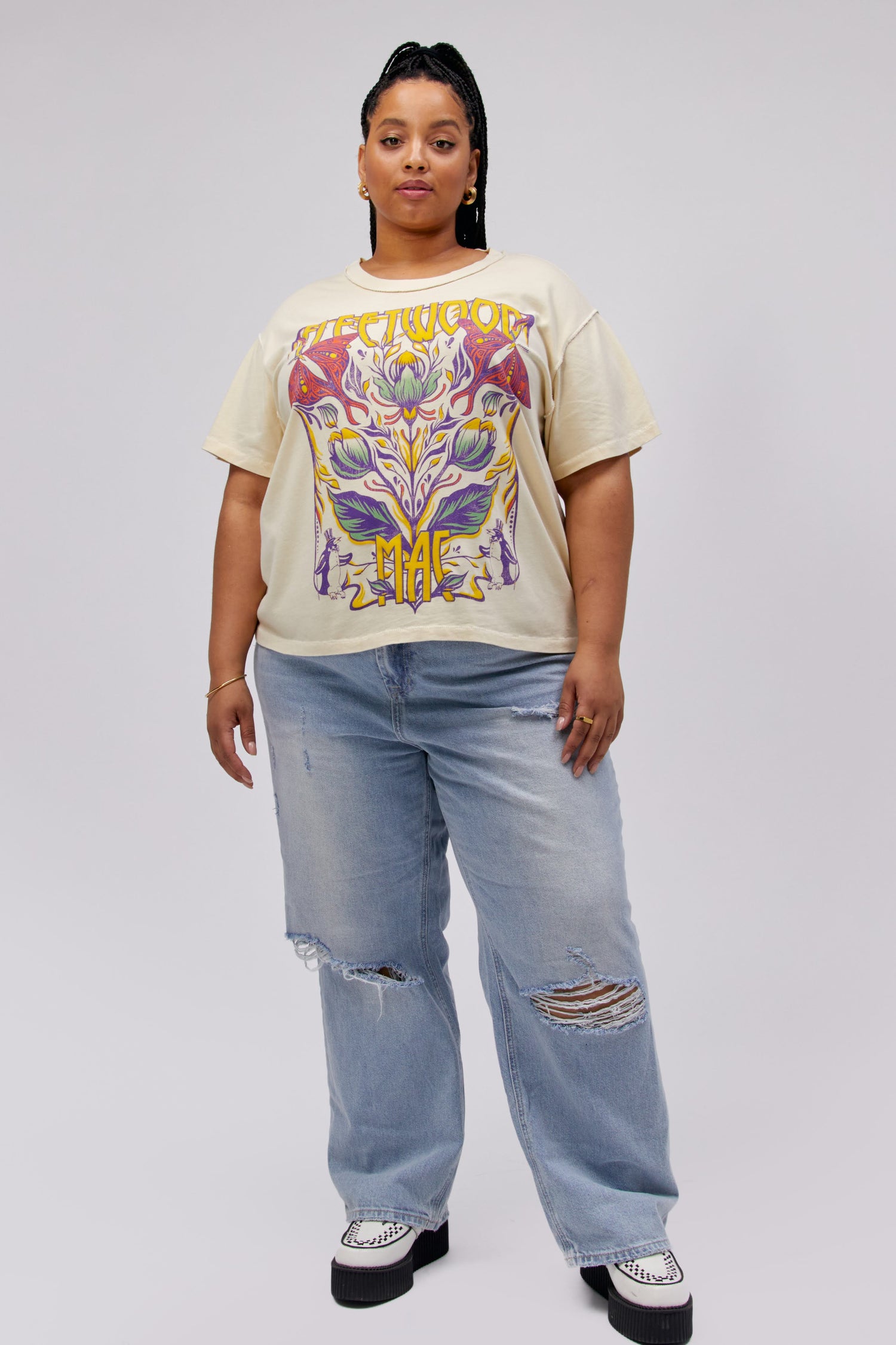 Plus size model wearing an off white Fleetwood Mac graphic tee with butterfly artwork and reverse seam details.